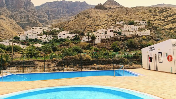 Una piscina con vistas a edificios blancos en una colina.