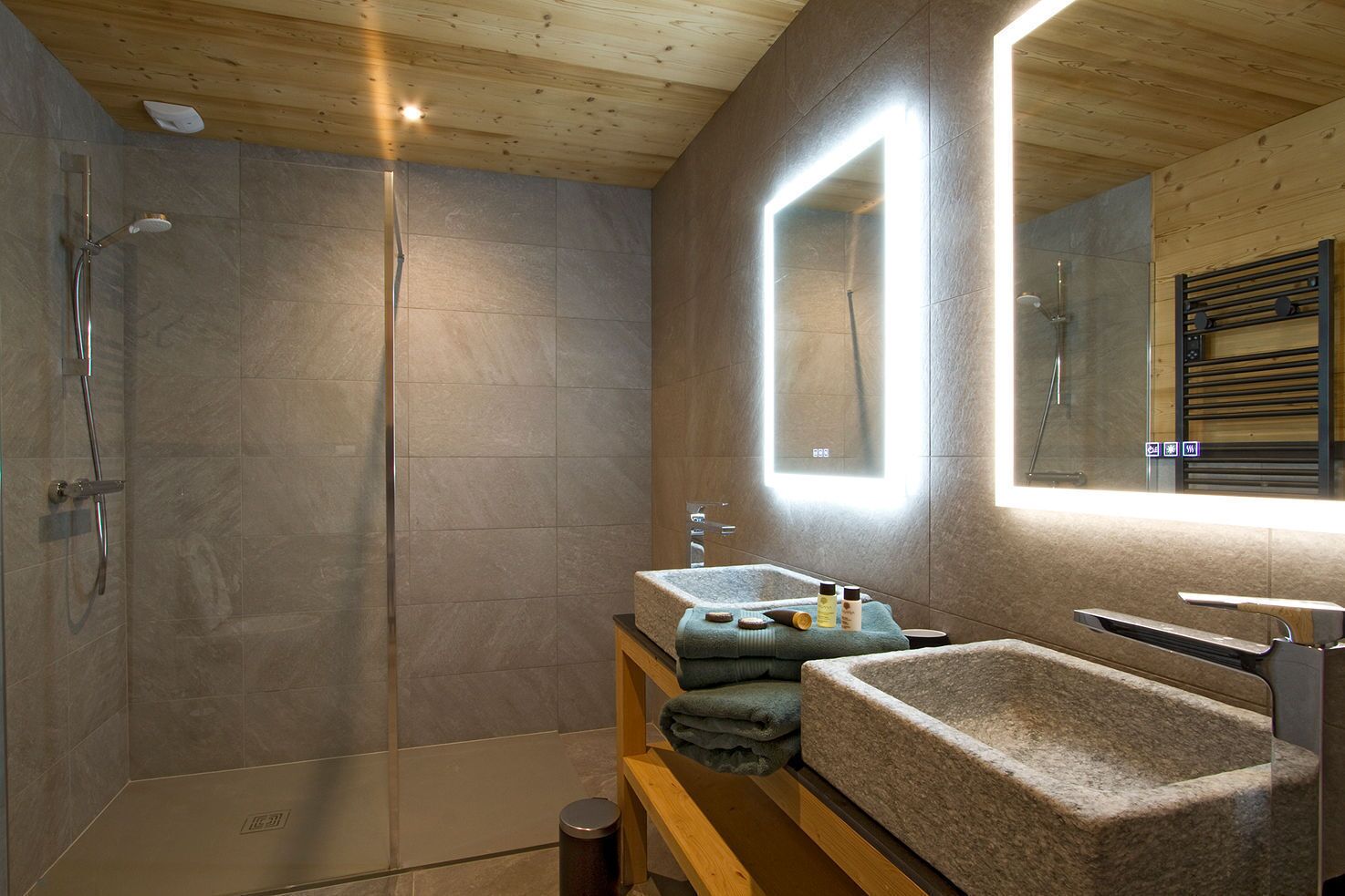 Un bany modern amb dutxa, un lavabo i un mirall.