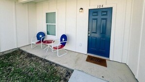A house with a blue door marked "104" and a "hello" mat at the entrance. - 2-bedroom apartment in lovely Victoria with WiFi, AC (Victoria)