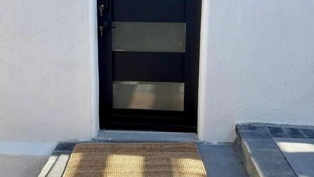 A black door with frosted glass panels, a small black sign above it, and a doormat at the entrance. - NEW Cozy Studio City Guesthouse in Prime Location (Los Angeles)
