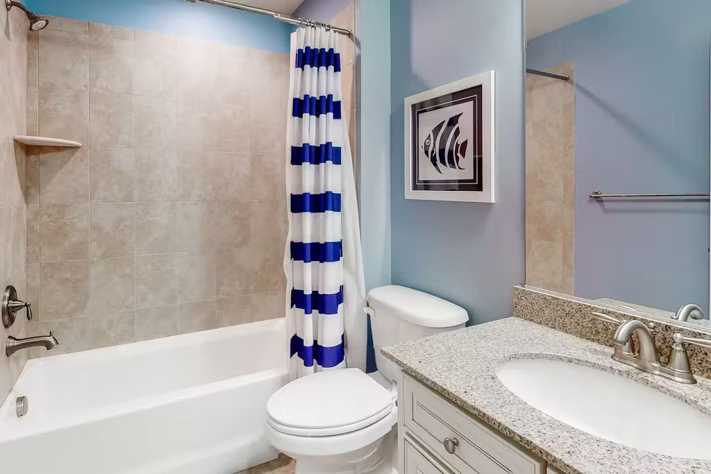 A bathroom with a bathtub, toilet, and sink.