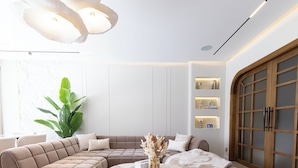 Een moderne woonkamer met een modulaire bank, een marmeren salontafel en een grote plant.