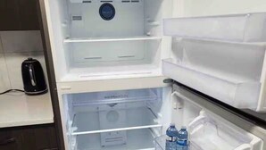 An open refrigerator with multiple shelves and a water dispenser. - Modern, well furnished 1 bedroom home with free street parking (Spruce Grove)