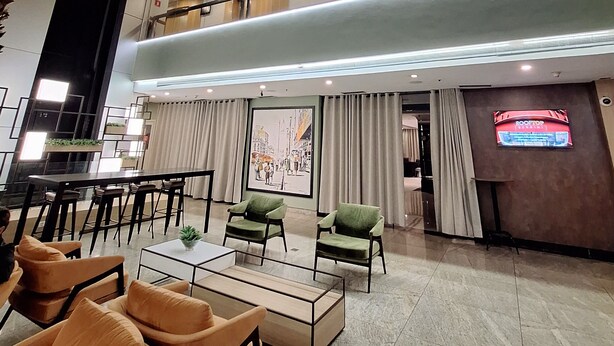 Un'ampia hall con soffitto alto, un'area bar e diverse zone relax.