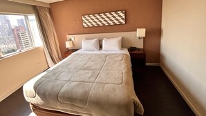 Una camera d'albergo con un letto grande, vista sulla città e una decorazione murale a scacchi.