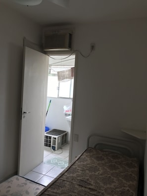 A room with a bed, a radiator, and a door leading to another room. - PENTHOUSE PENTHOUSE (Balneario Cidade Atlantica Guarujá)