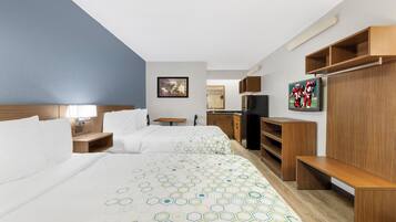 A hotel room with two beds, a TV, wooden furniture, and a painting on the wall.