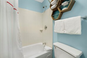 Ein Badezimmer mit Badewanne, Toilette und Duschvorhang.