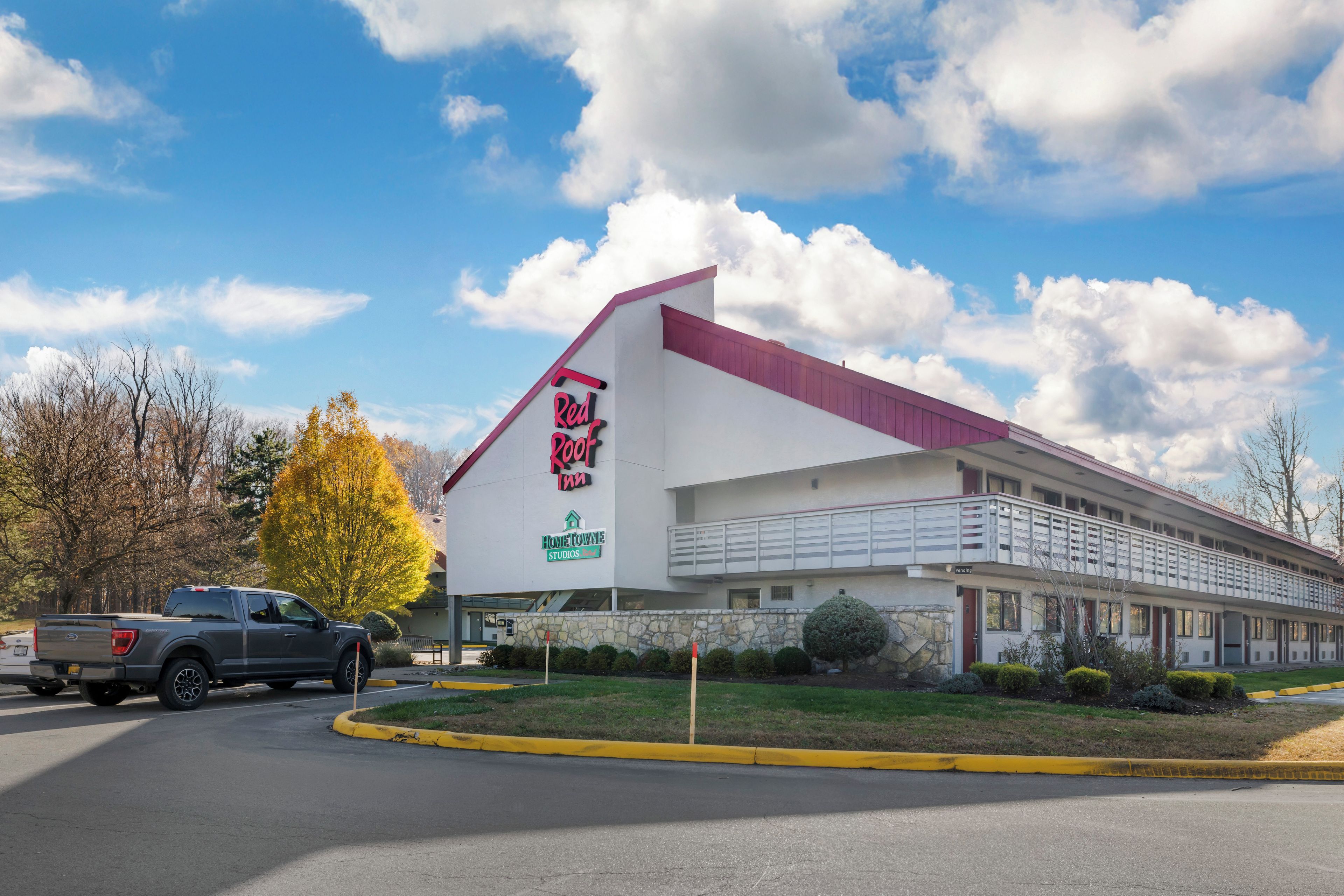 Un motel con techo rojo y un letrero que dice 'Red Roof Inn'.