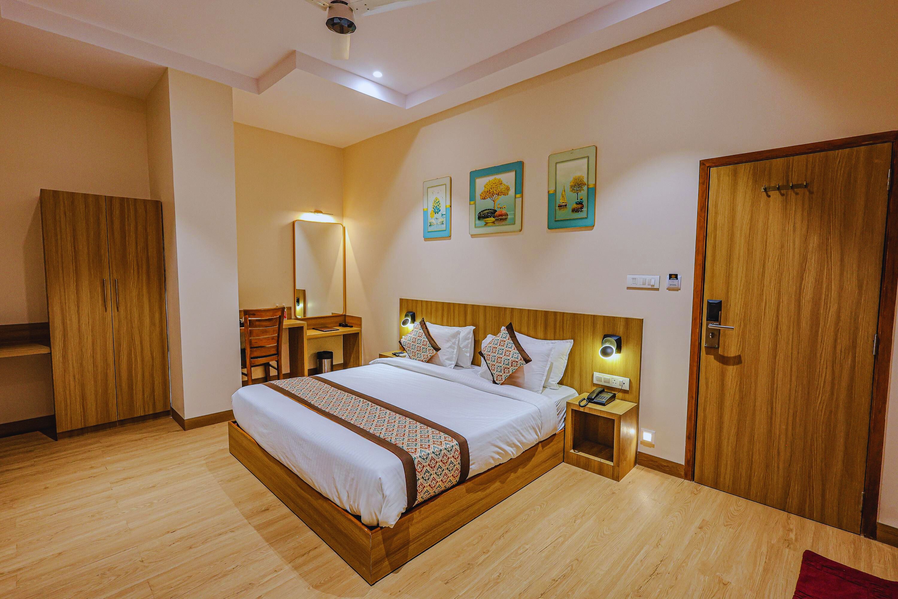 Un dormitorio ordenado con una cama grande, un armario de madera, mesitas de noche y una puerta.