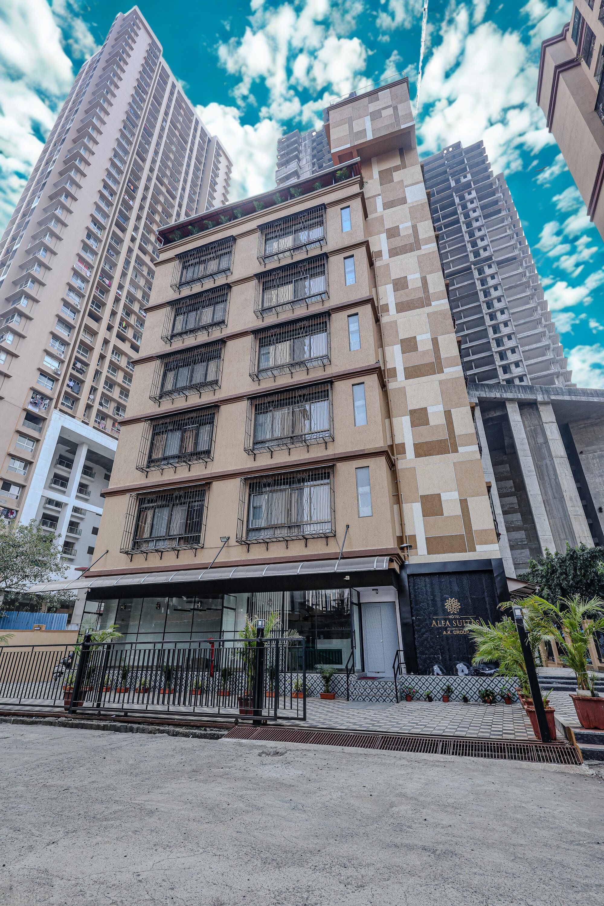 Un edificio de varios pisos con un diseño arquitectónico moderno, que destaca por una entrada principal con fachada de vidrio y puerta metálica.