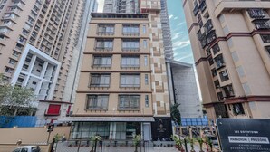 A multi-story residential building with balconies, large windows, and a modern architectural design. - Hotel Alfa Suites (Mumbai)