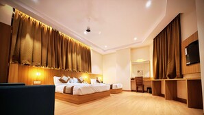 Une chambre d’hôtel avec un grand lit, un bureau, une chaise et un téléviseur.