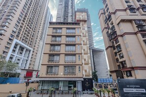 A multi-story hotel with a modern design, featuring balconies and large windows. - Hotel Alfa Suites (Mumbai)