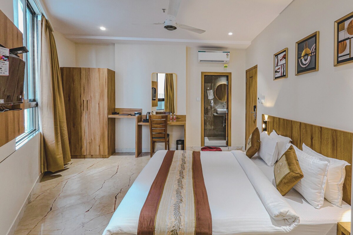 Una habitación de hotel con una cama grande, un escritorio, un armario y un espejo.