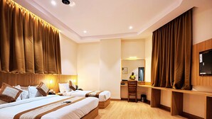 Une chambre d’hôtel avec un grand lit, un bureau, une chaise et un téléviseur.