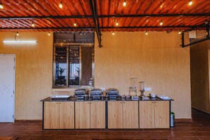 Ein Buffet mit mehreren Servierstationen, ein Fenster mit Blick und eine Decke mit freiliegenden Balken und Beleuchtung.