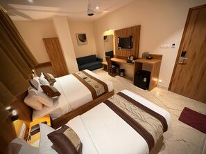 A hotel room with two beds, a desk, a chair, a television, and a mirror. - Hotel Alfa Suites (Mumbai)