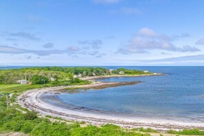A coastal landscape with a curved shoreline, a small beach, and a few buildings. - Granite Point Spacious and Elegant Family Retreat (Biddeford)