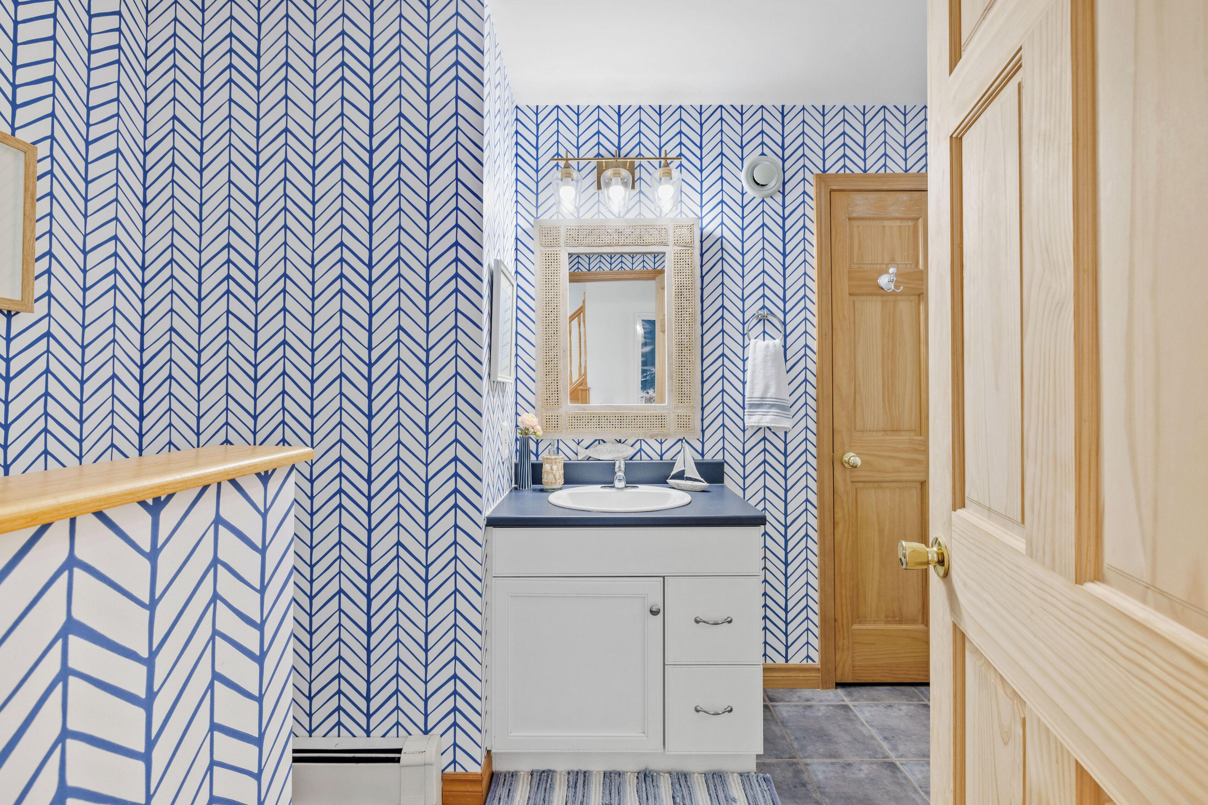 Une salle de bain avec un miroir, un lavabo et une porte en bois.