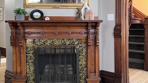 A grand fireplace with intricate woodwork and a large mirror above it. - The Tower on Summit (Eau Claire)