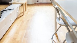 Une cuisine moderne équipée d’un four encastré, d’une table à manger et d’un banc.