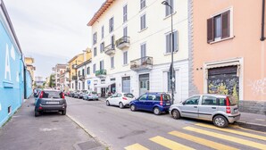 Une rue bordée de voitures garées et d’immeubles.