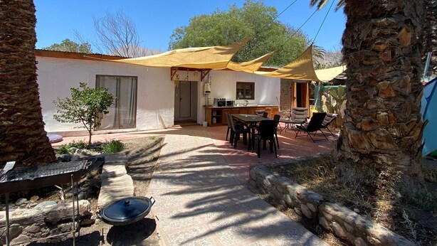 Un espace patio comprenant une table et des chaises, un barbecue et un petit coin cuisine avec un évier et une cuisinière.