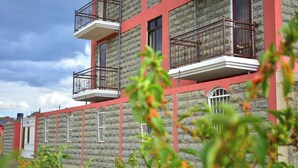 A multi-story building with balconies, stone facade, and a clear sky. - The Urban Cabin Naivasha (Naivasha)