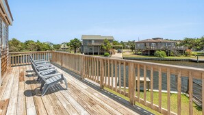 A wooden deck with lounge chairs overlooking a water body, surrounded by residential buildings. - Surf'n Sound: Canalfront | Gas Grill (Avon)
