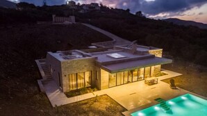 A modern house with a swimming pool, large windows, and a staircase leading to the upper level. - Modern and stylish with sea view (crete)