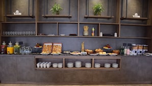 A buffet setup with various food items, drinks, and utensils. - Tótem Hotel & Spa (San Martin)