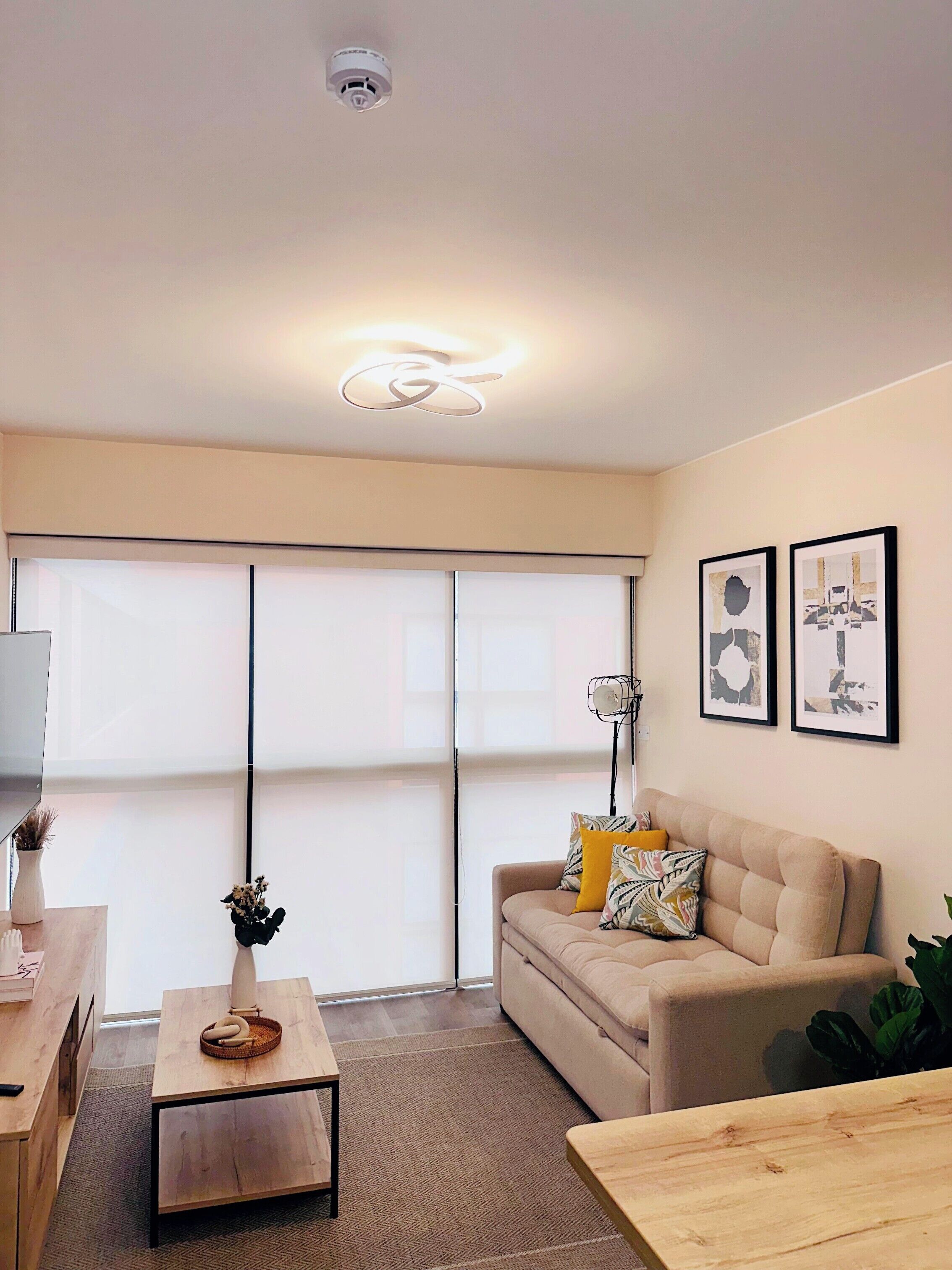 Ein modernes Wohnzimmer mit einer Couch, einem Couchtisch und Kunstwerken an der Wand.