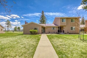 A two-story house with a front yard and a pathway leading to the entrance. - Bright Townhouse with Sunroom & AC Near Lakes (Pagosa Springs)