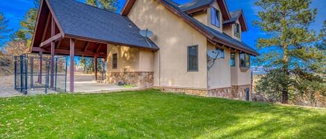 A two-story house with a covered porch, stone foundation, and satellite dishes.