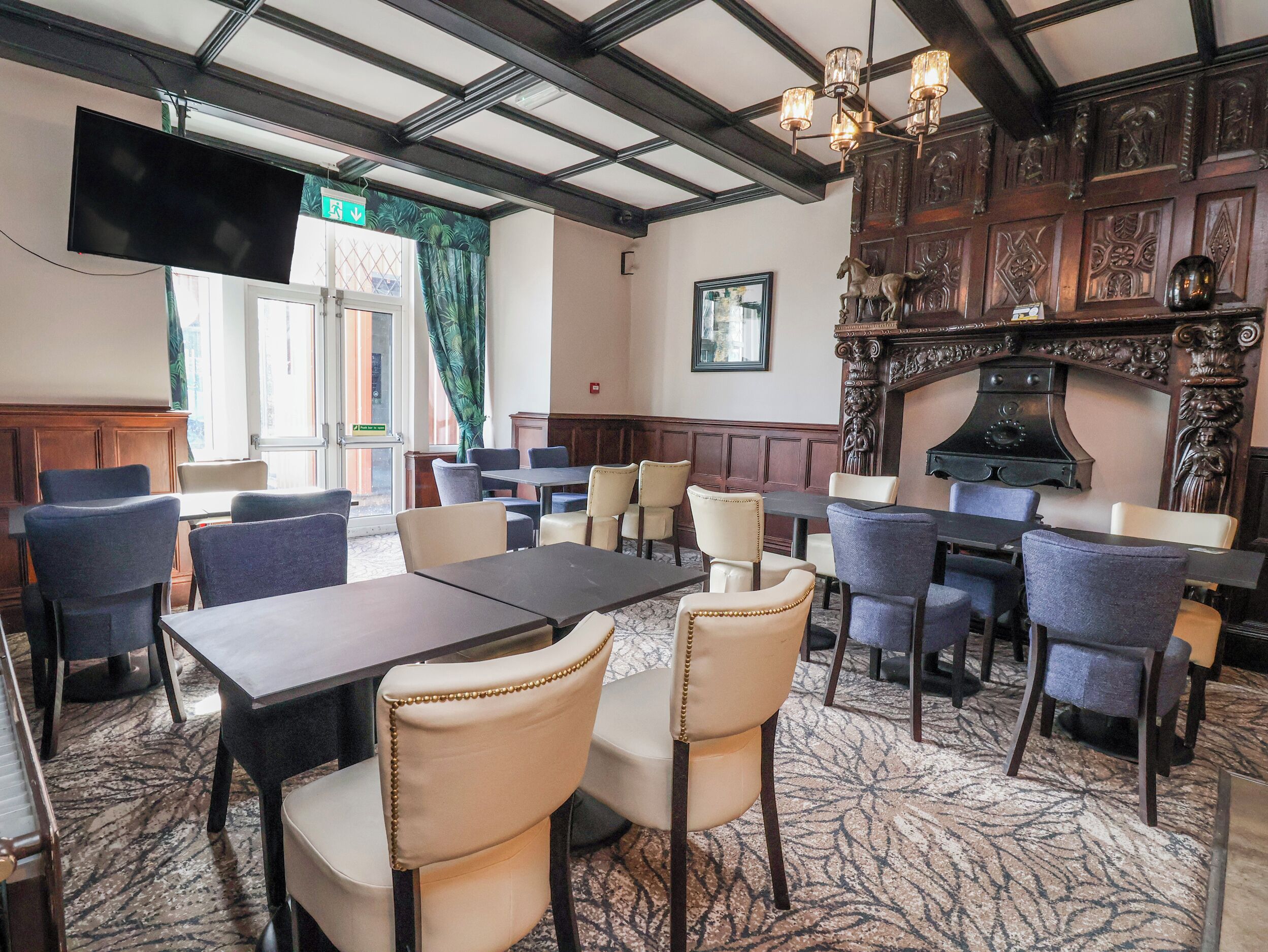 A conference room with a large table, chairs, a television, and a fireplace.