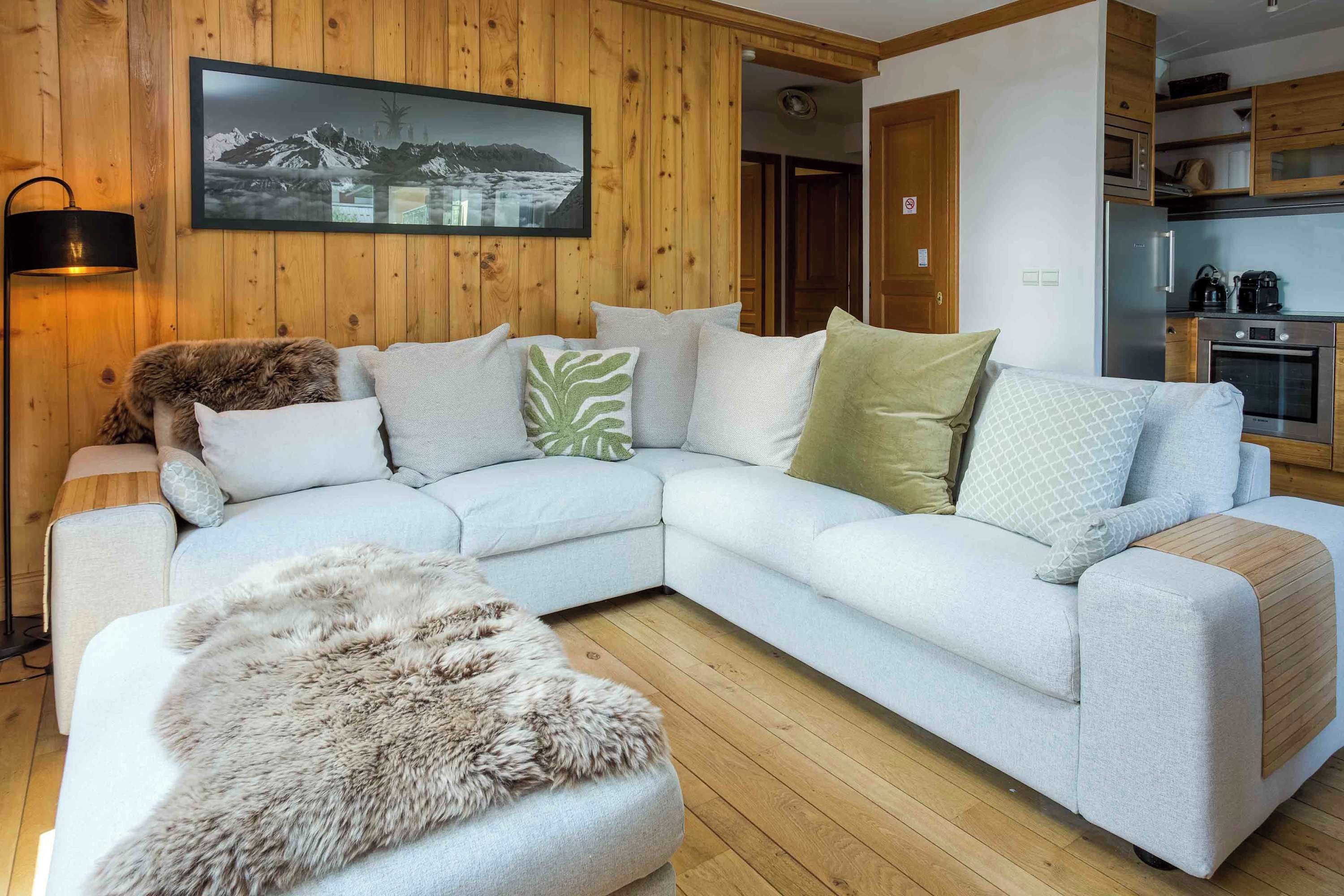A modern living room with a sectional sofa, a fur throw, and a framed picture on the wall.