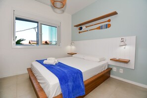 Una camera da letto ordinata con un letto, una finestra e uno scaffale a parete con diversi oggetti.