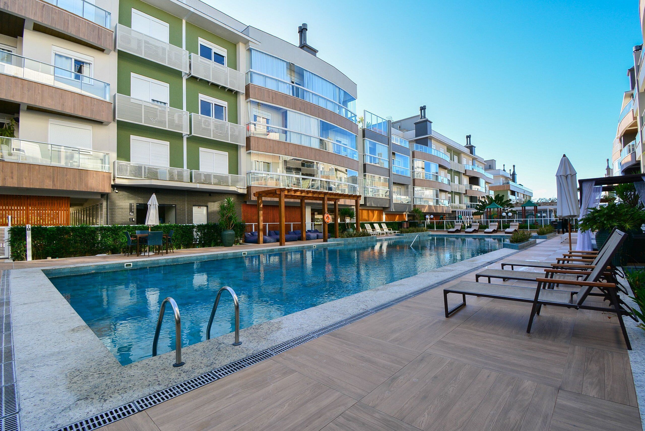 Un hôtel moderne doté d’une piscine, d’un espace extérieur aménagé et de balcons.