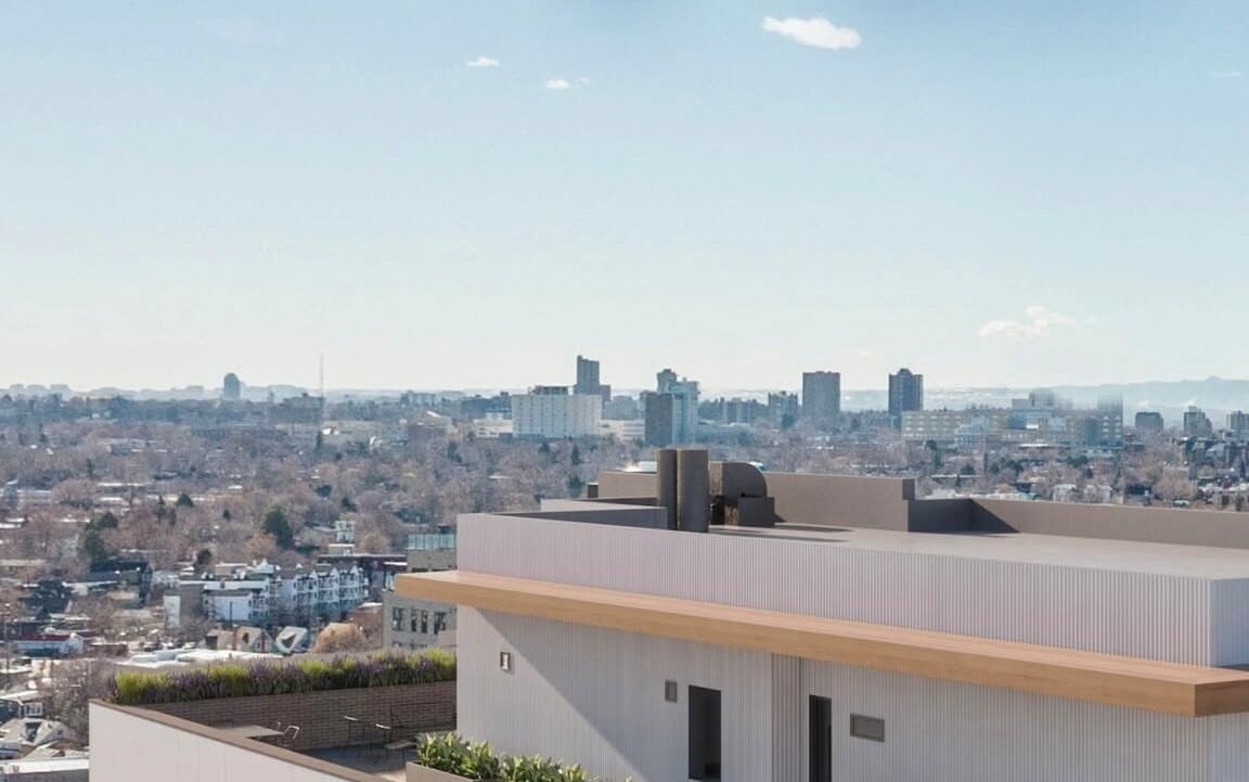 A modern building with a flat roof and a view of a cityscape in the background.