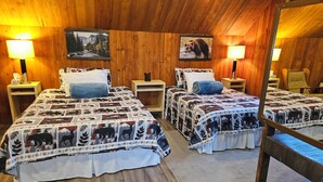 A cozy cabin room with two beds, wooden walls, and a large mirror. - Cabin Style Private Studio  (Giroux)