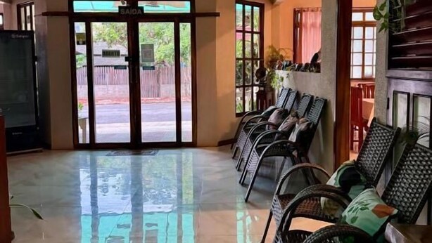 A spacious lobby with a tiled floor, a chandelier, a fan, and a seating area with chairs. - Pousada Cabocla (Santarém)