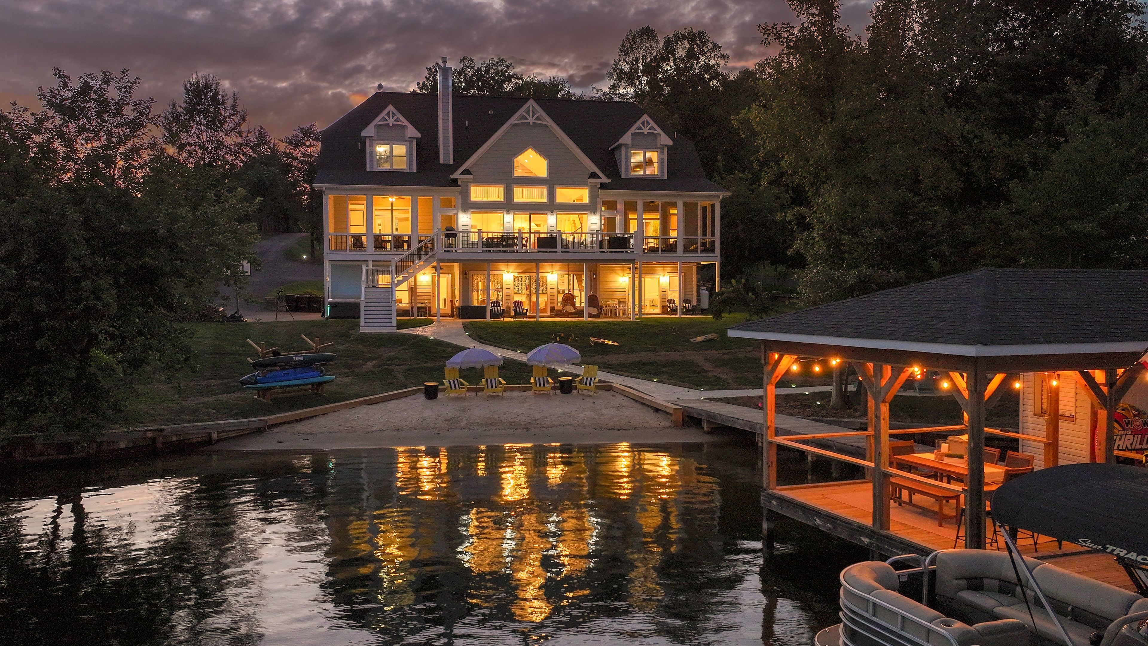 A large house with a dock and a covered area with seating.