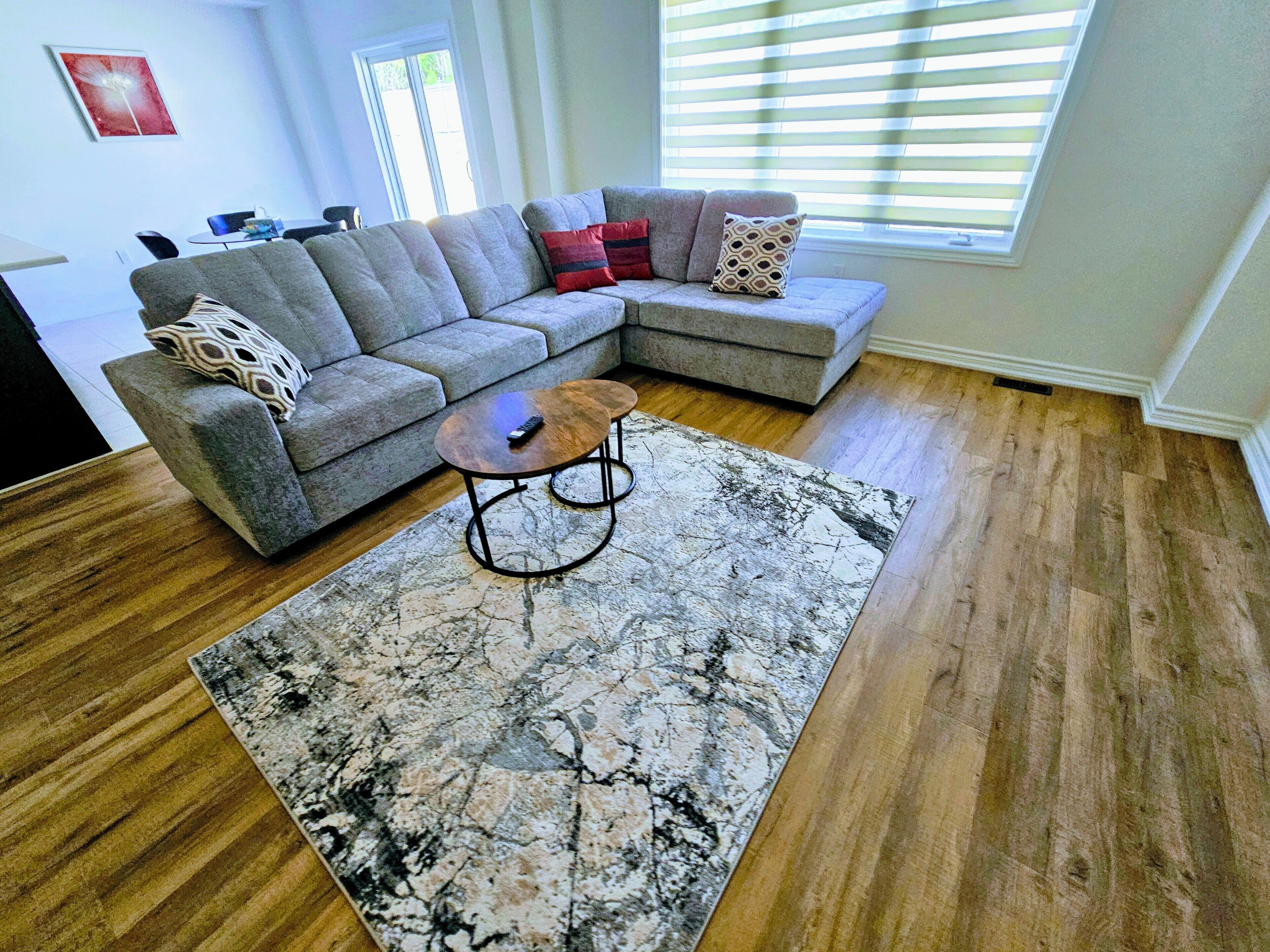 A living room with a sectional sofa, a coffee table, and a patterned rug.