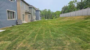 A residential area with houses, a well-maintained lawn, and a wooden fence. - Charming 4-bedroom cottage in Gravenhurst with WiFi and AC (Gravenhurst)