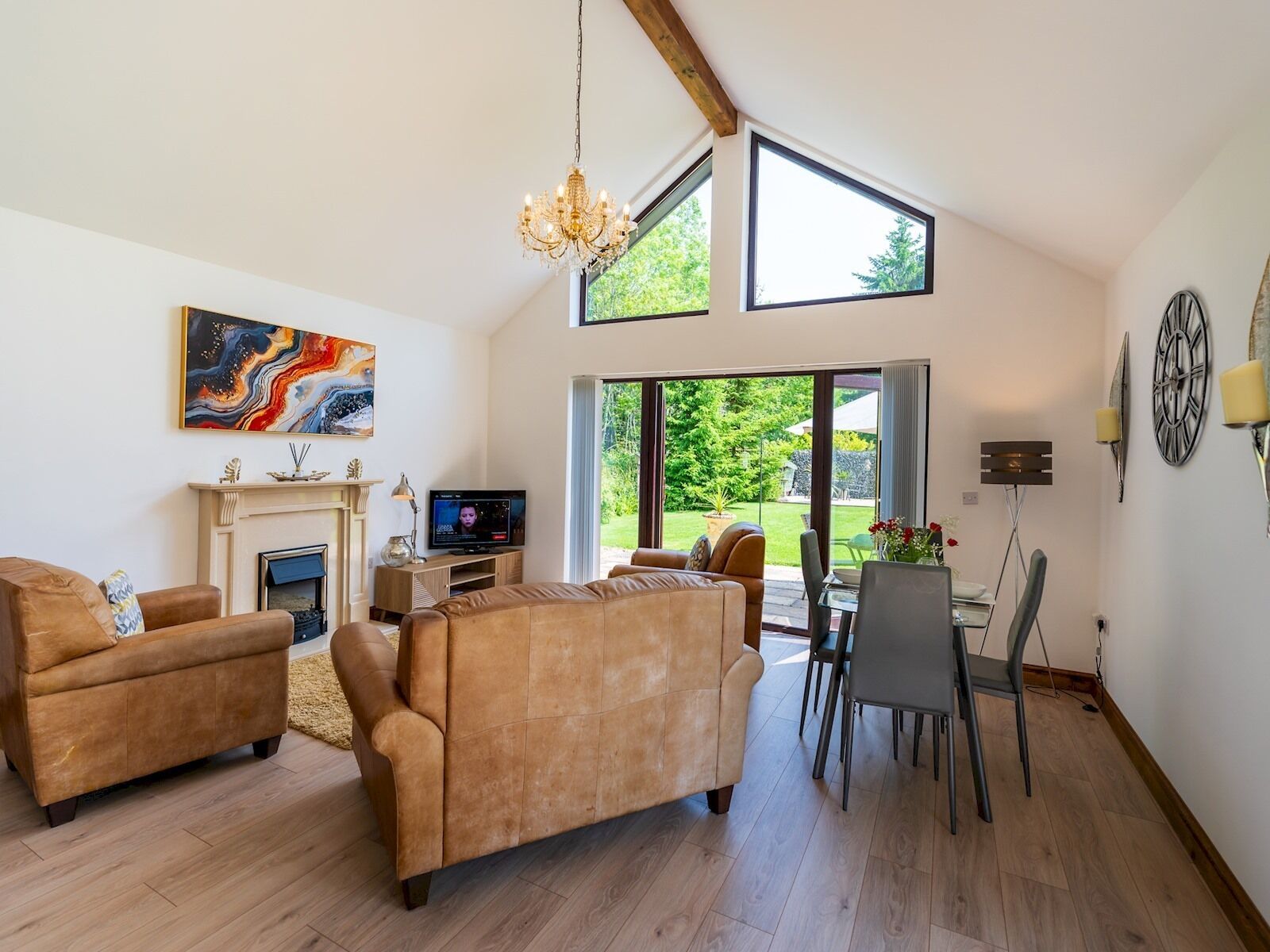 A spacious living room with a fireplace, a television, and a dining area with a table and chairs.