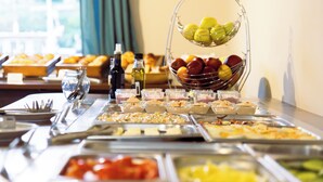 A buffet table with various food items and a fruit basket. - Aquamarina Hotel Visegrád (Visegrád)
