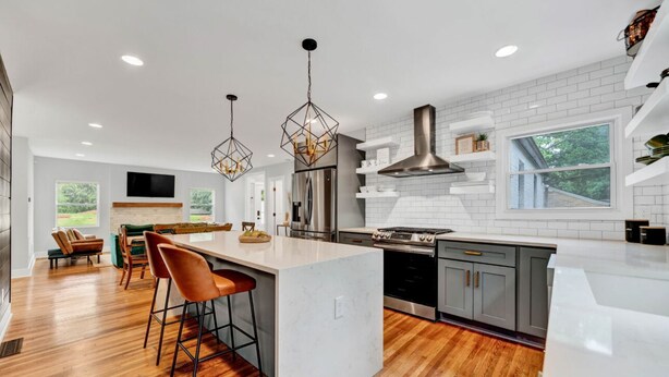 A modern kitchen with a large island, bar stools, pendant lighting, and a view of the outdoors. - Modern Farmhouse in the City -  4-bedroom house in charming Atlanta (Atlanta)