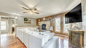 A spacious living room with a sectional sofa, a fireplace, and a large TV. - 1 Block to Hiking: Ruidoso Home w/ Game Room (Ruidoso)