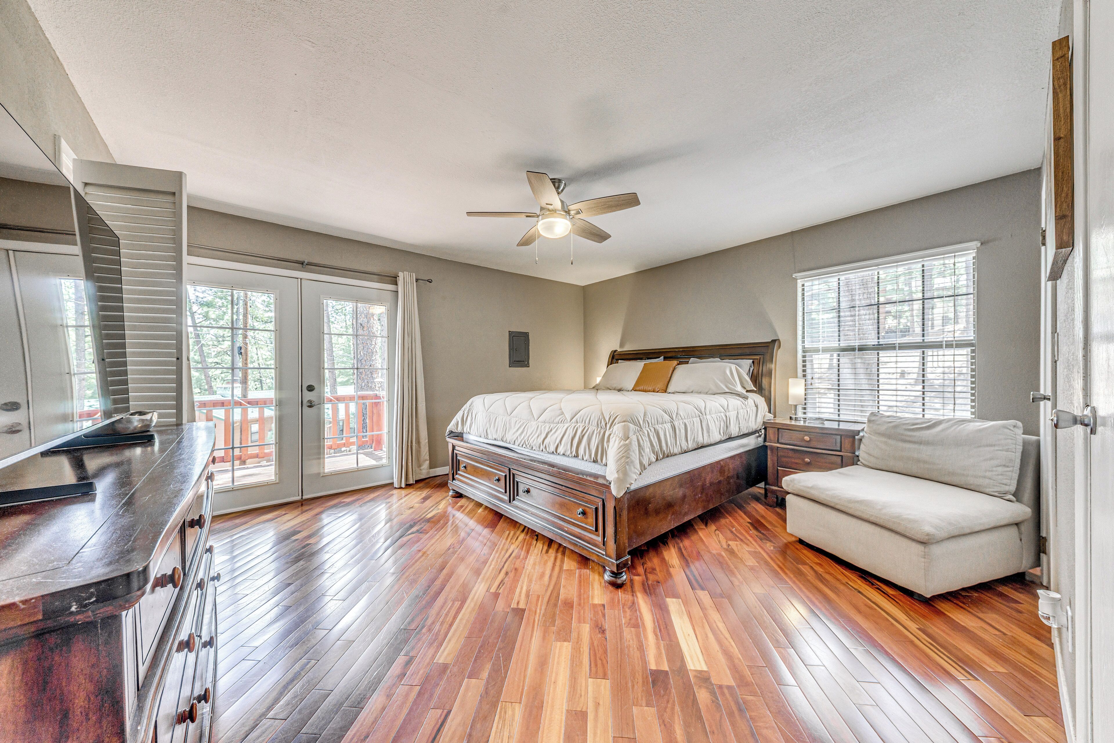 A bedroom with a bed, a nightstand, a chair, a dresser, and a ceiling fan.